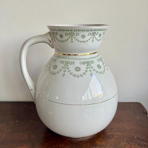 Może przedstawiać: Zestaw trzech ceramicznych kubków z nakrapianym, matowym wykończeniem. Kubki są w odcieniach kremu, szarości i czerni. Każdy kubek ma prosty, nowoczesny design, idealny do kawy lub herbaty. Kubki są ułożone jeden na drugim.