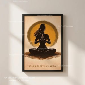 Puede incluir: Impresión enmarcada con una silueta negra de una persona en postura de yoga, manos juntas, sobre un fondo de sol amarillo. Las palabras "SOLAR PLEXUS CHAKRA" están impresas en la parte inferior. Una obra de arte espiritual.