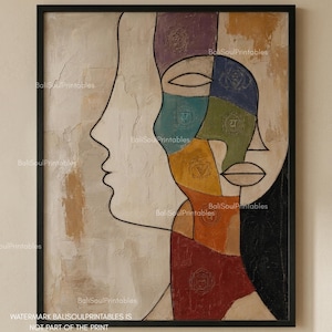 May include: A framed wall art print featuring a stylized profile of a face divided into sections of purple, blue, green, yellow, orange, and red, each containing a subtle chakra symbol. The background is a textured, neutral beige color.