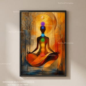May include: A framed wall art print featuring a silhouette of a person in a seated meditation pose. The figure displays seven vertically aligned, glowing coloured circles representing chakras against a warm, abstract orange and gold background.