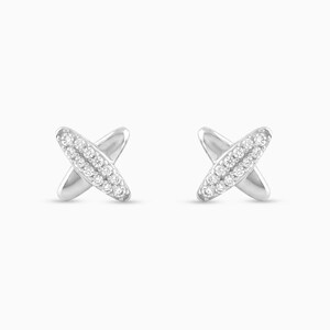 Peut inclure: Une paire de boucles d'oreilles clous argentées en forme de X. Le centre de chaque X est incrusté de petites pierres claires et scintillantes. Les boucles d'oreilles sont posées sur un fond blanc uni.