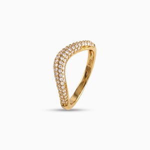 Peut inclure: Une bague en or avec un anneau ondulé et asymétrique, ornée d'un sertissage pavé de petites pierres claires rondes sur la surface supérieure. L'intérieur de l'anneau porte l'inscription KEER et un petit poinçon.