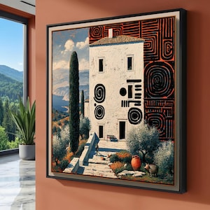 May include: A framed wall art print depicting a white multi-story building with black abstract spiral patterns on its facade. The scene includes a stone staircase, cypress trees, a terracotta pot, a small animal, and a coastal landscape background.