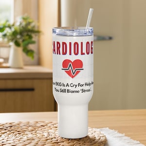 May include: White insulated tumbler with a clear straw. The tumbler features the word "CARDIOLOG" in red, a red heart with an EKG line, and the text "Our EKG Is A Cry For Help And You Still Blame 'Stress'" in black.