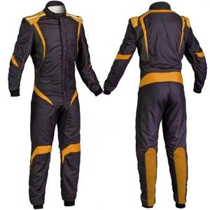 May include: Black and gold racing suit with a stand-up collar. The suit features gold accents on the shoulders, arms, and legs. The front of the suit has a zipper closure. The suit is designed for motorsports.