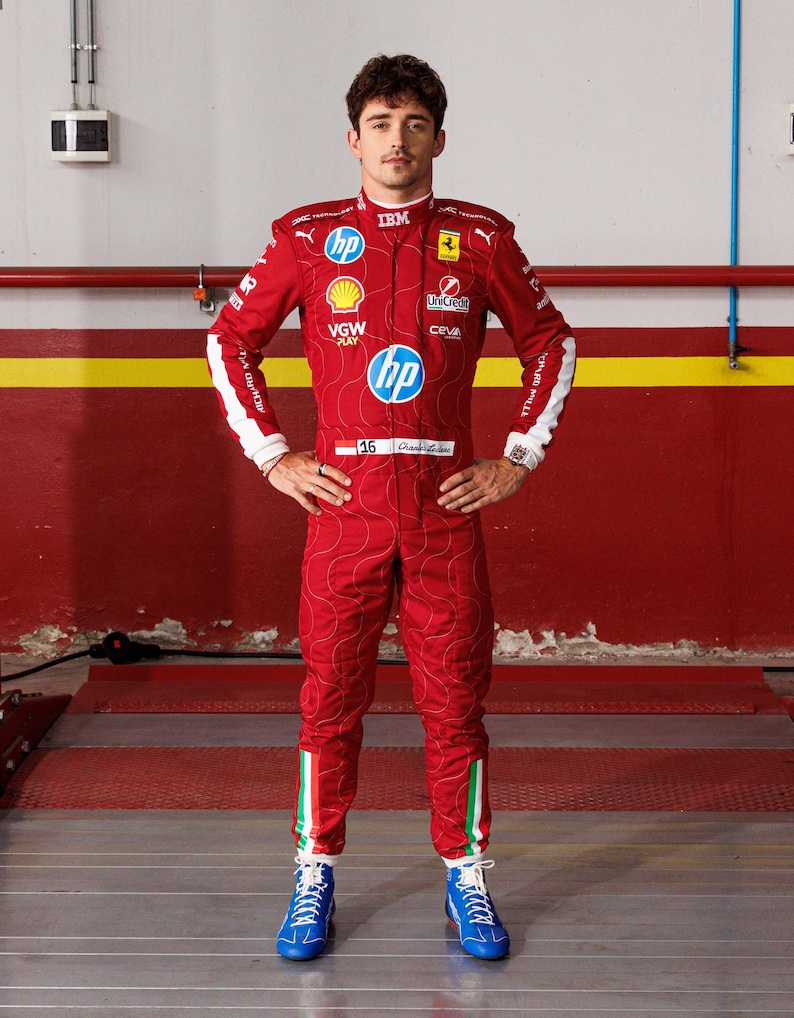May include: A red racing suit with sponsor logos, white accents, and blue shoes. The suit features the number 16 and the name "Charles Leclerc". The suit has a quilted pattern and Italian flag stripes on the legs.