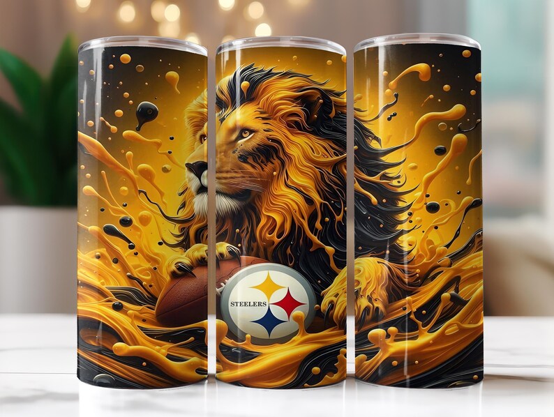 Op de afbeelding: Drie roestvrijstalen bekers met een leeuwenontwerp, een voetbal en het Pittsburgh Steelers-logo. De leeuw is goud en zwart, met een spatteffect. De bekers zijn cilindrisch.
