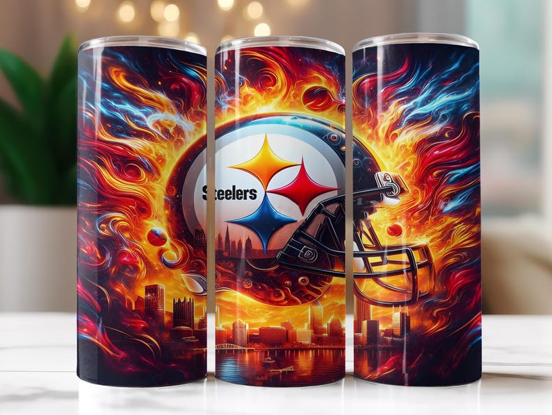 Op de afbeelding: Drie roestvrijstalen bekers tonen het logo van de Pittsburgh Steelers, een voetbalhelm en een stadsgezicht. De achtergrond toont vurige kleuren van rood, oranje en blauw, wat een dynamische en opvallende esthetiek cre&euml;ert.