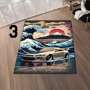 Puede incluir: Alfombra rectangular con un diseño de olas japonesas y un coche deportivo plateado. El fondo incluye el monte Fuji, un sol rojo y flores de cerezo. El número "3" está en la esquina superior izquierda.