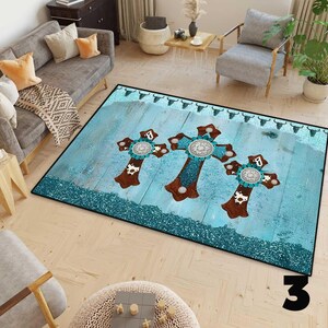May include: A rectangular rug with a turquoise and brown cross design. The rug features three large crosses with turquoise and silver accents, set against a light blue wood-grain background. The border is a dark teal colour.