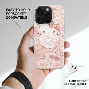 May include: A clear phone case with a pink Hello Kitty design and a popsocket. The case features a repeating pattern of Hello Kitty, bows, and other cute elements. Text on the case reads "Hello Kitty", "Easy to hold Popsocket compatible", and "Light weight soft and flexible".