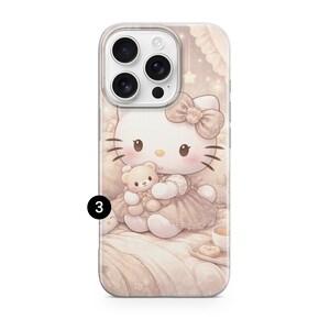 May include: A phone case with a cartoon illustration of Hello Kitty holding a teddy bear. The design uses soft pastel colours, with a bow on Hello Kitty's head and a cup of tea and a donut on a tray. The case is designed for a smartphone.