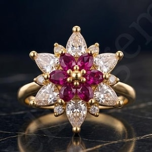 Könnte beinhalten: Ein Goldring mit floralem Design, bestehend aus einer zentralen Gruppe von sechs tiefrosa Rubinen im Marquise-Schliff um eine kleine Goldperle, umrahmt von einer äußeren Schicht aus sechs klaren weißen Diamanten im Marquise-Schliff auf einem Goldring.