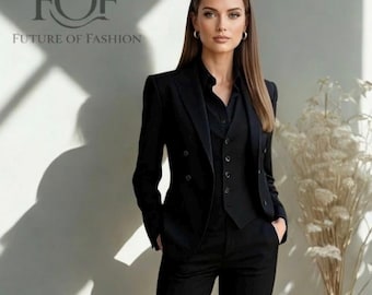 May include: A woman wearing a black suit, consisting of a blazer, vest, and trousers. The suit is paired with a black collared shirt. The image includes the text "FOF FUTURE OF FASHION" in the upper left corner. The background is a plain white wall.