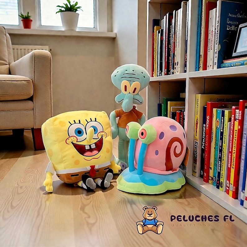 K&ouml;nnte beinhalten: Pl&uuml;schtiere mit Figuren aus der Zeichentrickserie SpongeBob Schwammkopf: SpongeBob, Thadd&auml;us und Gary die Schnecke. Die Spielzeuge befinden sich in einem Raum mit einem B&uuml;cherregal und einem Sofa.