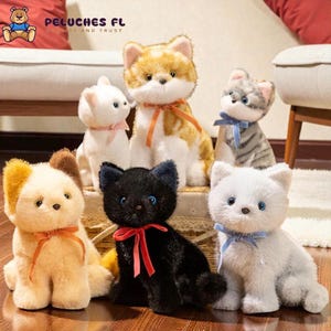 Peut inclure: Plusieurs chats en peluche de différentes couleurs, dont blanc, noir, orange et gris. Chaque chat porte un ruban autour du cou. La marque "PELUCHES FL" est visible en haut à gauche.