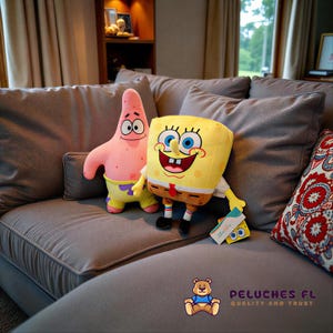 K&ouml;nnte beinhalten: Zwei Pl&uuml;schtiere von SpongeBob Schwammkopf und Patrick Star aus der Zeichentrickserie, auf einem grauen Sofa. SpongeBob ist gelb mit roter Krawatte, und Patrick ist rosa. Ein Etikett mit einem SpongeBob-Bild ist sichtbar.