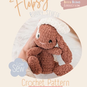 May include: A crocheted bunny stuffie in shades of brown and white. The bunny has a textured appearance with a white head and a brown body. The image includes the text "Flopsy Bunny Stuffie", "Low Sew", and "Crochet Pattern".