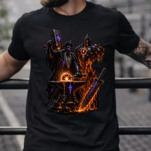 May include: A black short-sleeved t-shirt featuring a graphic print of a bearded figure in dark armor hammering a glowing object on an anvil. Beside the figure stands a second armored entity with a sword, both surrounded by orange flames and purple light.