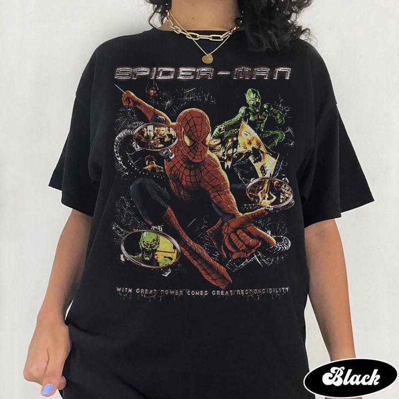 May include: Black Spider-Man graphic t-shirt featuring the superhero in action with the text "SPIDER-MAN" at the top. The shirt also includes the quote "WITH GREAT POWER COMES GREAT RESPONSIBILITY".