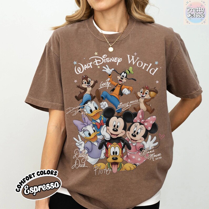 May include: Espresso-colored t-shirt featuring a graphic of Disney characters, including Mickey and Minnie Mouse, Donald and Daisy Duck, Goofy, Pluto, and Chip and Dale. The text "Walt Disney World" is above the characters. The shirt is part of the Comfort Colors collection.