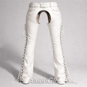 May include: White leather chaps with a belt, pockets, and lace-up sides. The chaps have a unique open back design. The AmeriGlo logo is visible at the bottom.