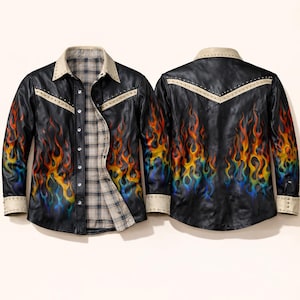 Puede incluir: Camisa de cuero negro con un diseño de llamas coloridas. La camisa presenta un forro a cuadros, detalles en crema y detalles de tachuelas plateadas. Tiene mangas largas y cierre de botones.