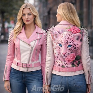 May include: Pink and white leather jacket with silver studs on the shoulders and sleeves. The back of the jacket features a pink leopard design with blue eyes and pink roses. The jacket has a belt and multiple zippers.