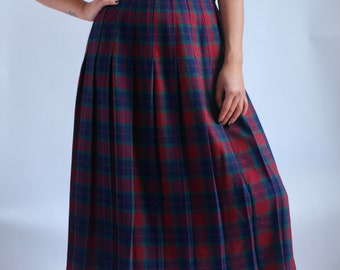 May include: A red, blue, and green plaid pleated skirt. The skirt is knee-length and has a fitted waist.