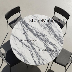 Könnte beinhalten: Draufsicht auf einen runden Marmortisch mit grauer Maserung, umgeben von vier grauen Stühlen. Auf dem Tisch steht der Text "StoneMiningArts". Die Stühle haben ein minimalistisches Design mit schlanken schwarzen Beinen.