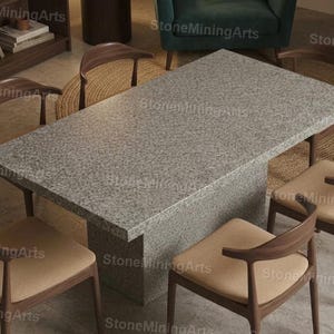 Puede incluir: Una mesa rectangular de piedra gris moteada con una base a juego, rodeada de seis sillas de madera con cojines color beige. Las sillas tienen respaldos y patas curvadas. La mesa es el punto focal de un comedor moderno.