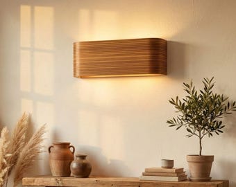 Puede incluir: Una escena de salón cálida y acogedora con una lámpara de pared de madera, una consola rústica de madera y un sillón beige con una manta de punto. Los elementos decorativos incluyen un jarrón de hierba de la pampa y un pequeño olivo en maceta.