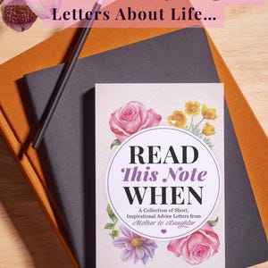 Puede incluir: Un libro titulado Read This Note WHEN: A Collection of Short, Inspirational Advice Letters from Mother to Daughter de Shelley Carroll, con ilustraciones florales, sobre un cuaderno negro, un cuaderno naranja y un l&aacute;piz.