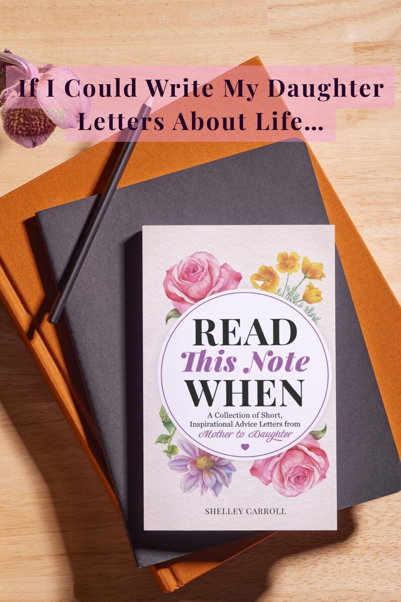 Puede incluir: Un libro titulado Read This Note WHEN: A Collection of Short, Inspirational Advice Letters from Mother to Daughter de Shelley Carroll, con ilustraciones florales, sobre un cuaderno negro, un cuaderno naranja y un l&aacute;piz.
