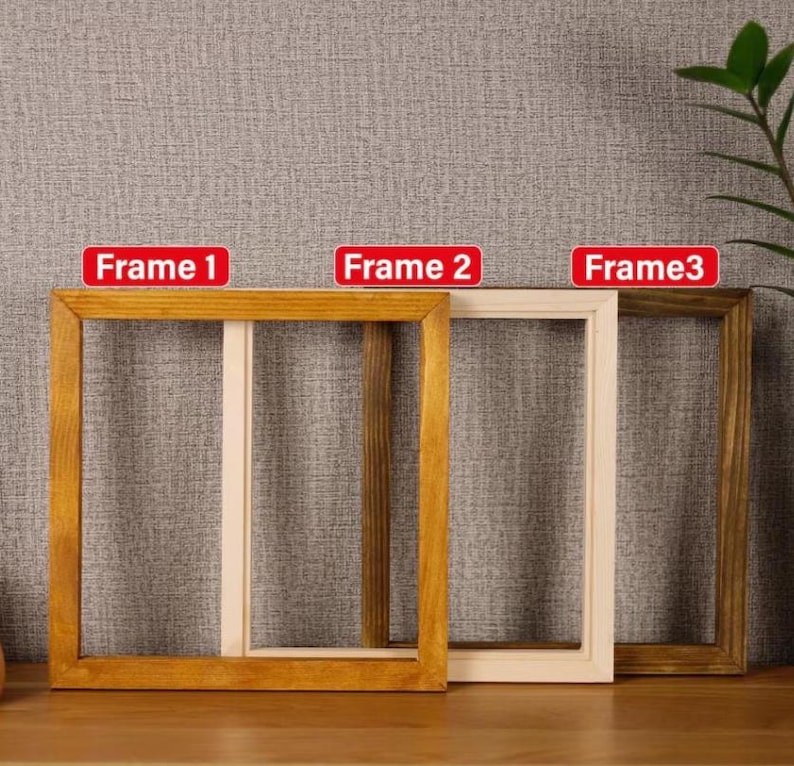 Puede incluir: Se muestran tres marcos de fotos de madera en diferentes tonos de marr&oacute;n y beige. Los marcos son rectangulares con vetas de madera visibles. El texto "Frame 1", "Frame 2" y "Frame 3" est&aacute; en rect&aacute;ngulos rojos.