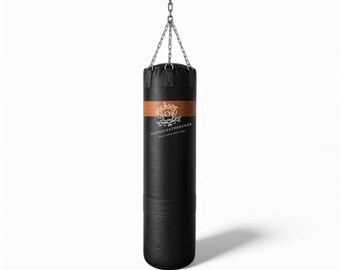 May include: Black leather punching bag suspended from a chain. The bag features a brown band with a logo and text. The cylindrical bag is designed for boxing or martial arts training. The bag hangs against a white backdrop.