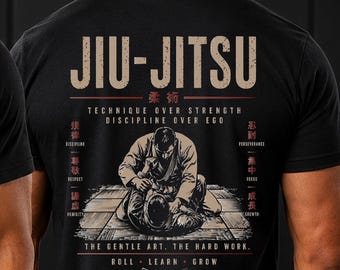 Puede incluir: Una camiseta negra con un gráfico en la espalda de dos personas practicando jiu-jitsu. El diseño incluye el texto JIU-JITSU, TECHNIQUE OVER STRENGTH, DISCIPLINE OVER EGO, THE GENTLE ART. THE HARD WORK. ROLL. LEARN. GROW.