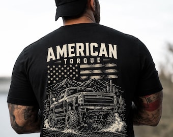 May include: Black t-shirt with the words "AMERICAN TORQUE" above a graphic of an American flag and a lifted truck. The truck is kicking up dust in a desert landscape with mountains and cacti.