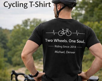 May include: Black cycling t-shirt with white text and graphics. The shirt features a bicycle graphic with the text "Two Wheels. One Soul." and "Riding Since: 2014." The shirt also includes the name "Michael, Denver" below the text. The words "Personalized Cycling T-Shirt" are at the top.