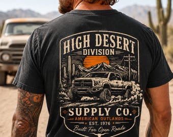 May include: Black t-shirt with a desert-themed graphic. The design includes a truck, mountains, and the text "HIGH DESERT DIVISION SUPPLY CO. AMERICAN OUTLANDS EST. 1976 Built For Open Roads."