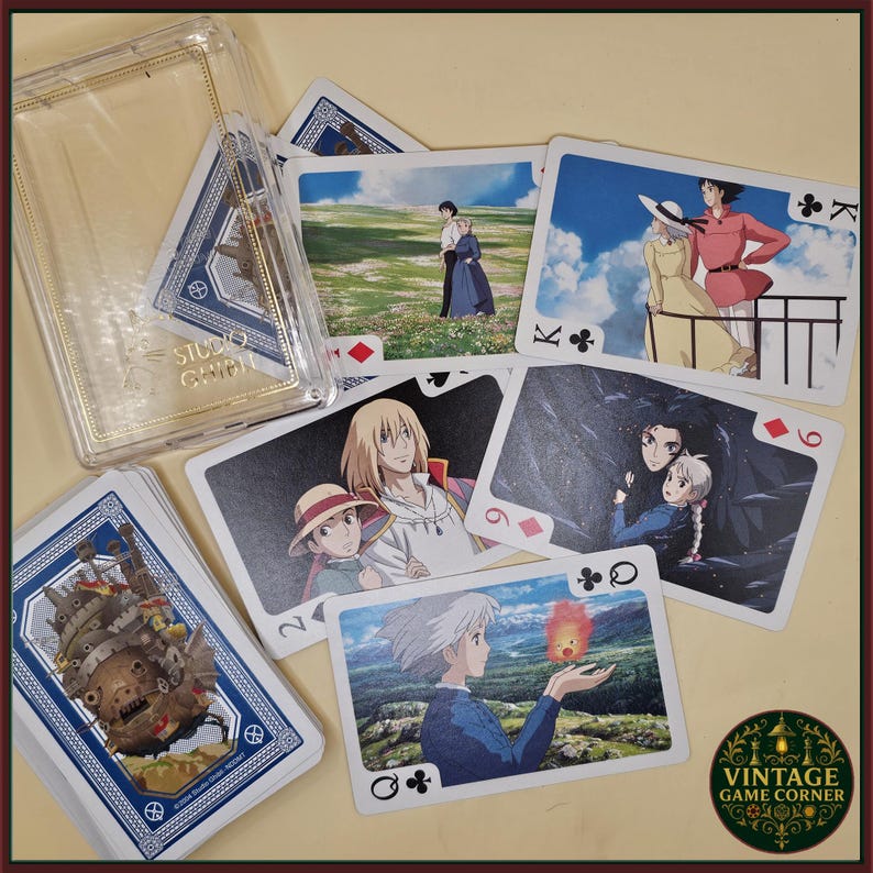 May include: A deck of playing cards featuring images from the animated film "Howl's Moving Castle." The cards are displayed with a clear plastic case and a "Studio Ghibli" logo. The deck has a blue border and the "Vintage Game Corner" logo.