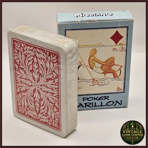 May include: A sealed deck of Modiano Poker Parillon playing cards. The card backs have a red floral design. The light blue card box features an illustration of a person in a boat and the text "POKER PARILLON".