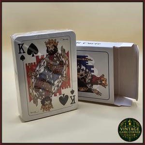 May include: A sealed deck of playing cards featuring a King of Spades card with a detailed illustration of a king in regal attire. The card deck is in a white box with a matching illustration. The words "Vintage Game Corner" are on the bottom right.