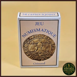 Puede incluir: Una caja blanca de naipes con el texto "54 cartes à jouer" en la parte superior. La caja presenta un diseño de moneda de color dorado con dos perfiles y la palabra "NUMISMATIQUE". La marca "Grimaud" está en la parte inferior.