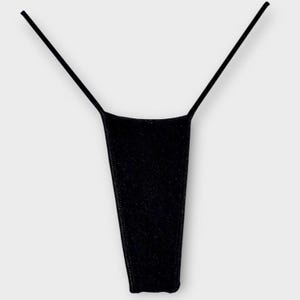 May include: A black thong with thin straps. The thong is made of a shiny, glittery material. The garment is displayed against a plain white background.
