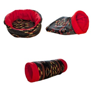 Peut inclure: Un ensemble de trois accessoires pour animaux en tissu sombre avec un motif g&eacute;om&eacute;trique noir, rouge, jaune et blanc, dot&eacute; d'une doublure int&eacute;rieure rouge vif. L'ensemble comprend un lit rond, une pochette pli&eacute;e et un tunnel cylindrique.