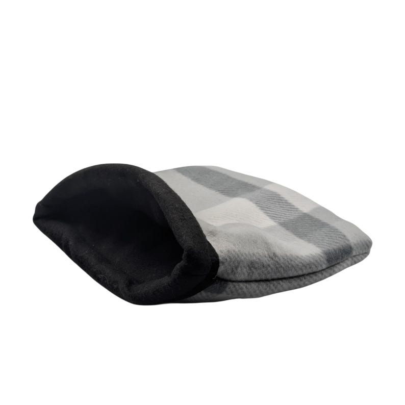 May include: A gray and white plaid flat cap with a black interior. The cap is made of a soft material and is designed in a classic style. The hat is a traditional accessory.