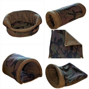 May include: A selection of pet accessories featuring a camouflage design. The image shows a round bed, a tunnel, and a blanket. The fabric is a blend of brown, green, and black, with a soft, plush texture. The edges are trimmed with a solid brown fabric.