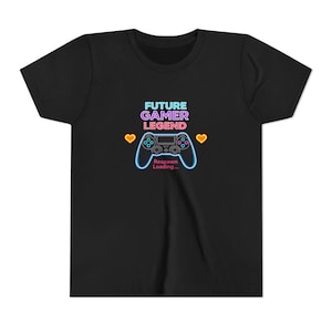 Può includere: T-shirt nero con grafica in stile neon. La grafica presenta un controller di gioco con la scritta "FUTURE GAMER LEGEND" sopra e "Respawn Loading..." sotto. Due cuori gialli affiancano il controller.