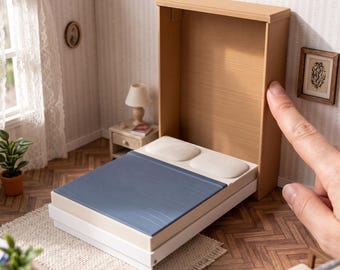 May include: A miniature wall bed in a light wood finish with a blue blanket and two white pillows, featuring the text DIGITAL STL FILES - NO PHYSICAL ITEM and INSTANT DOWNLOAD. This is a 3D printable model for dollhouse furniture.